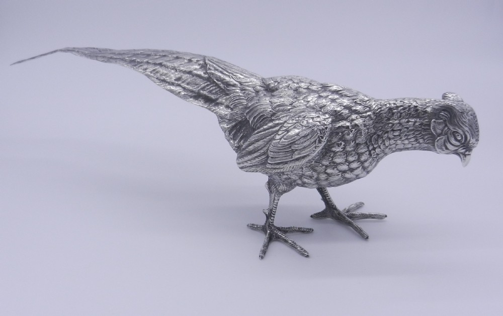 A pair of detailed cast silver pheasant figurines depicted standing in dynamic poses with extended tail feathers. View III