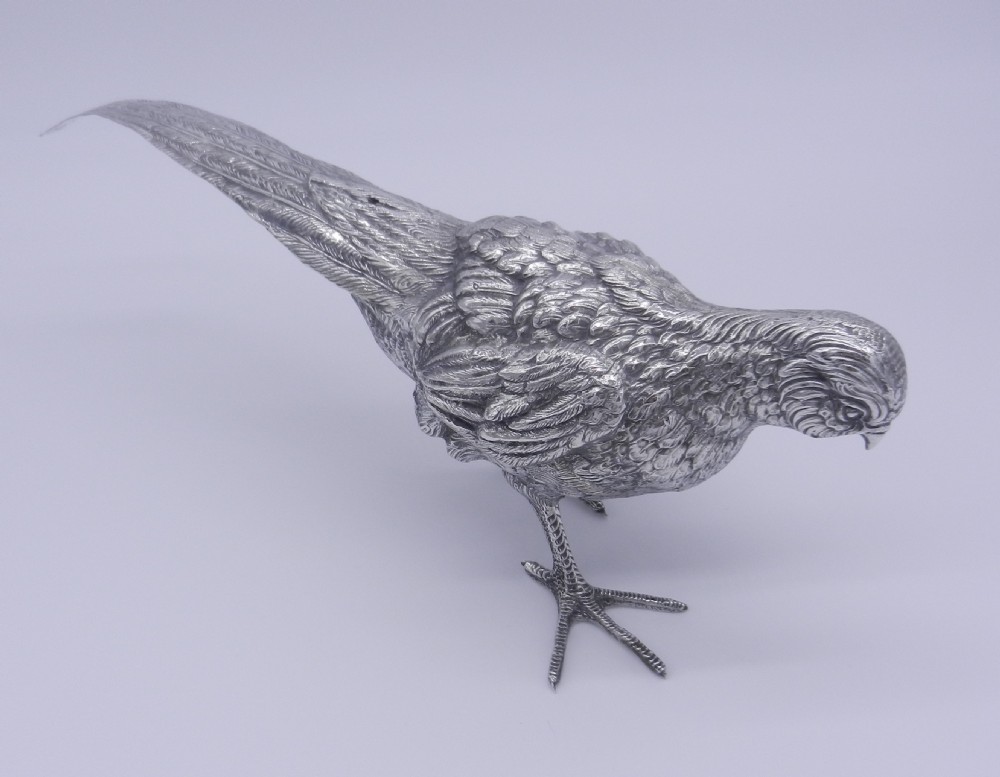 A pair of detailed cast silver pheasant figurines depicted standing in dynamic poses with extended tail feathers. View VI