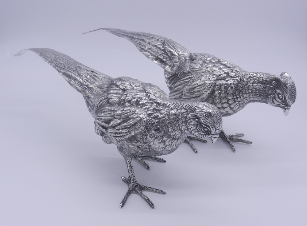 A pair of detailed cast silver pheasant figurines depicted standing in dynamic poses with extended tail feathers. View VII