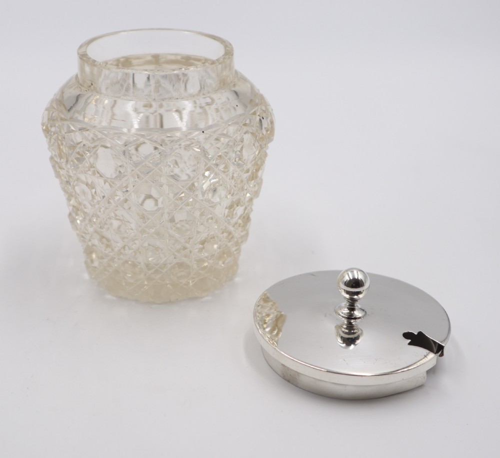 A clear cut-glass preserve pot featuring a geometric diamond pattern and a smooth polished silver lid with a rounded finial. View III
