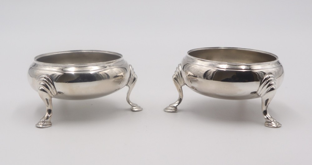 A pair of circular silver open salt cellars, each elevated on three cabriole legs with decorative knees and pad feet. View II