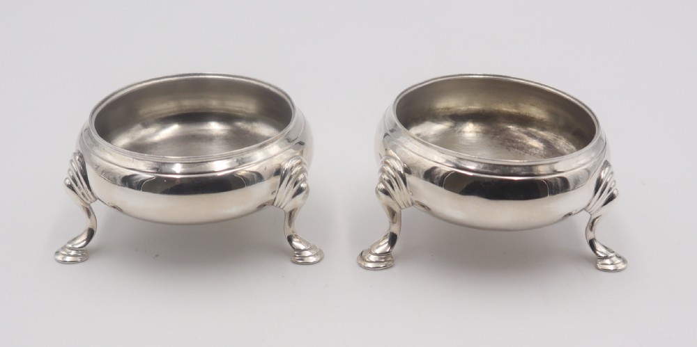 A pair of circular silver open salt cellars, each elevated on three cabriole legs with decorative knees and pad feet. View IV
