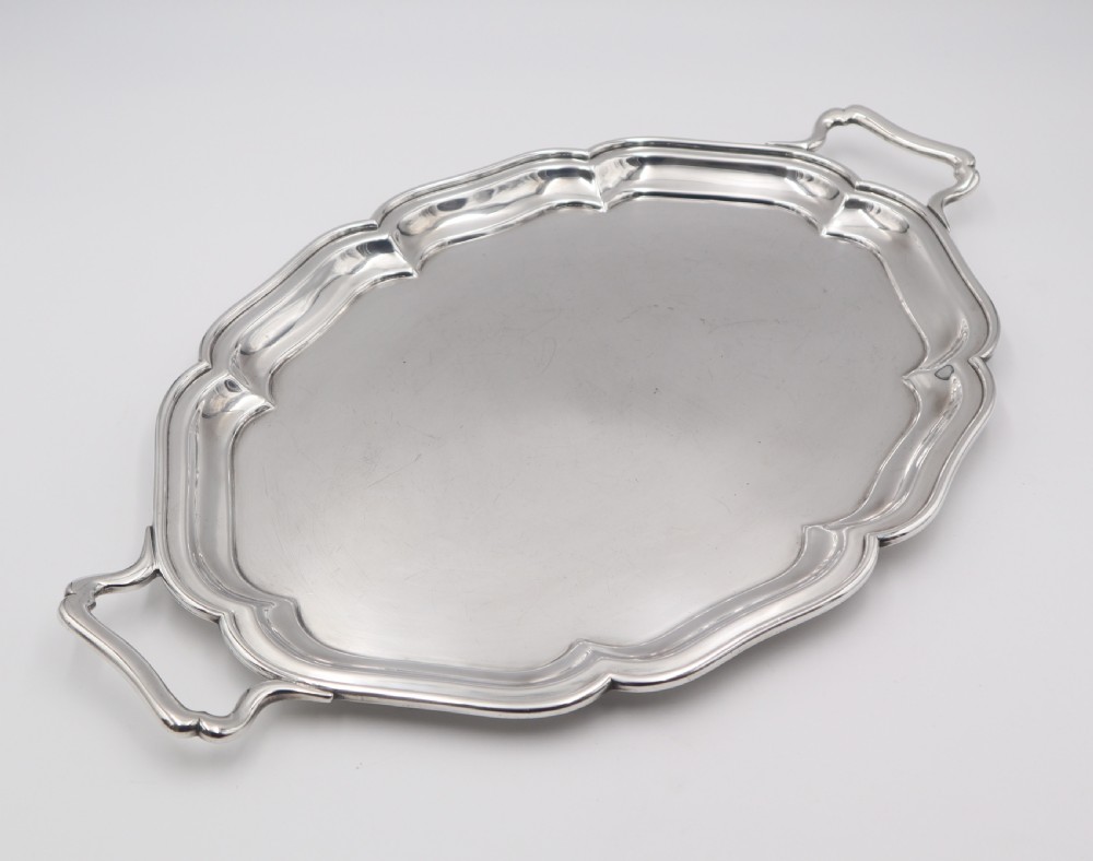 An oval silver-plated serving tray featuring a scalloped molded rim, twin integrated side handles, and a polished metallic surface. View II