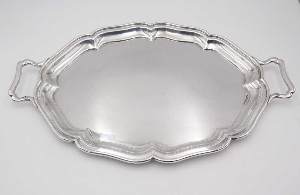 An oval silver-plated serving tray featuring a scalloped molded rim, twin integrated side handles, and a polished metallic surface. View III
