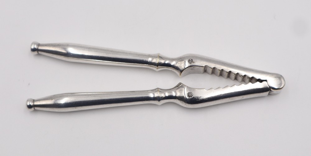 A pair of antique silver-plated nutcrackers featuring serrated inner jaws, stamped maker marks, and tapered fluted handles. View II
