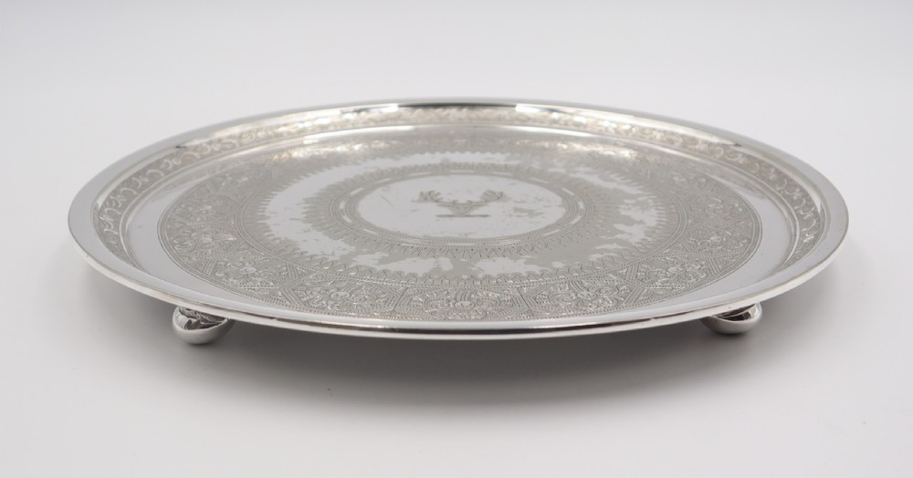 A circular silverplated salver featuring intricate engraved circular patterns and a central crest depicting a stags head. View II