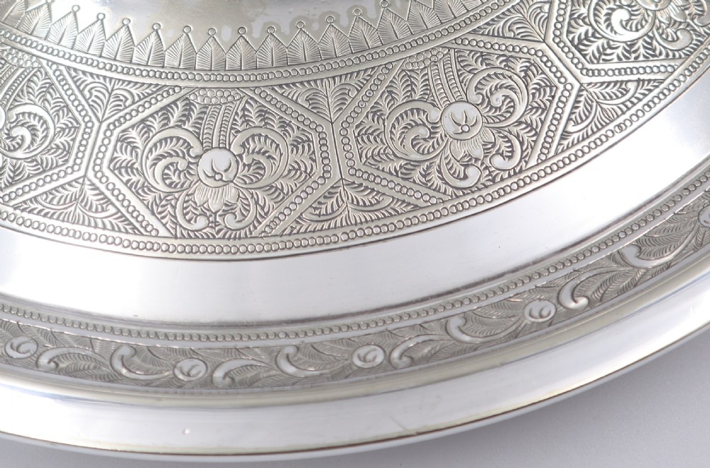 A circular silverplated salver featuring intricate engraved circular patterns and a central crest depicting a stags head. View III