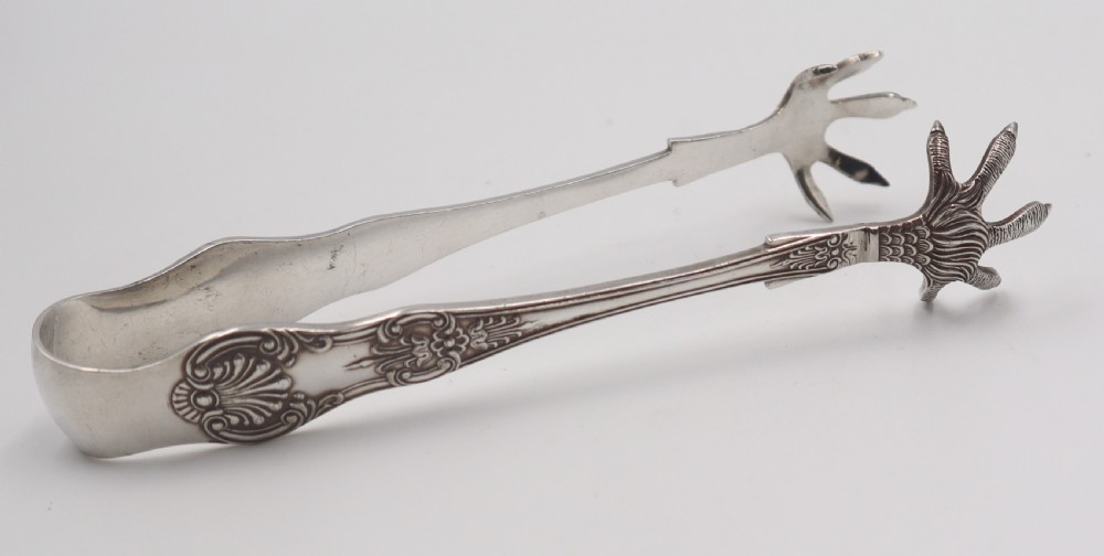 A pair of antique silverplate ice tongs featuring a sprung bow handle with shell reliefs and claw-shaped grips. View II