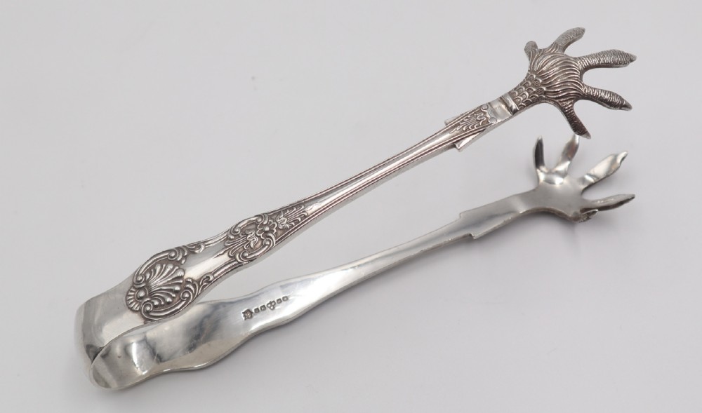 A pair of antique silverplate ice tongs featuring a sprung bow handle with shell reliefs and claw-shaped grips. View IV