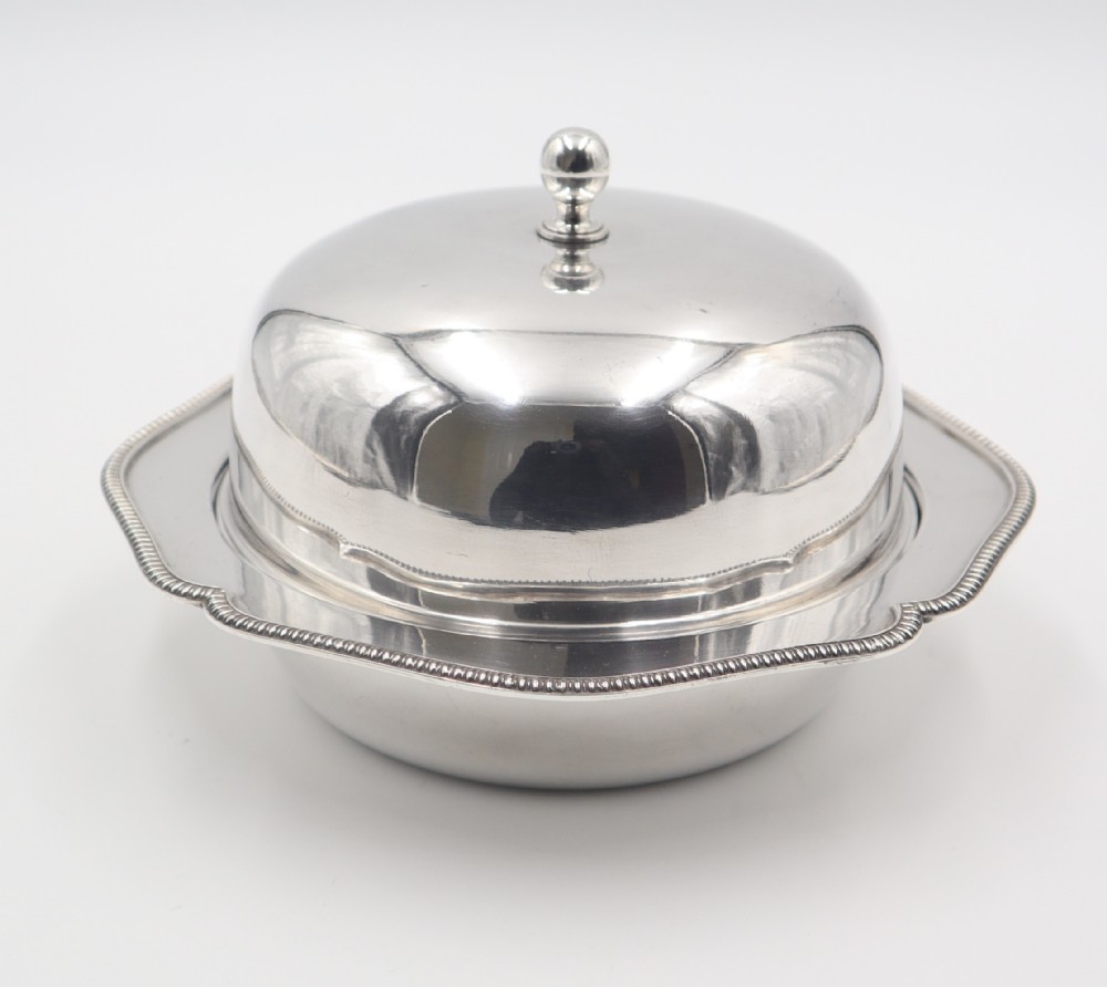 An antique silverplated muffin dish featuring a domed lid with a ball finial and a circular tray with a beaded edge.