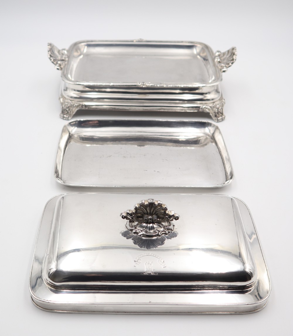 A rectangular silver-plated warming entree dish featuring shell-form handles, a domed lid with a shell finial, and a raised pedestal base. View IV