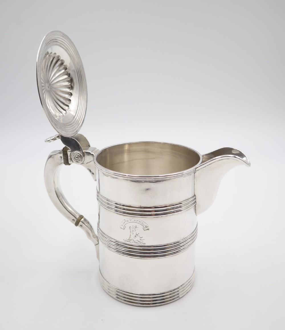 An antique silver Old Sheffield plate beer jug featuring reeded horizontal bands, a fluted hinged lid, an engraved heraldic crest, and a curved handle. View III