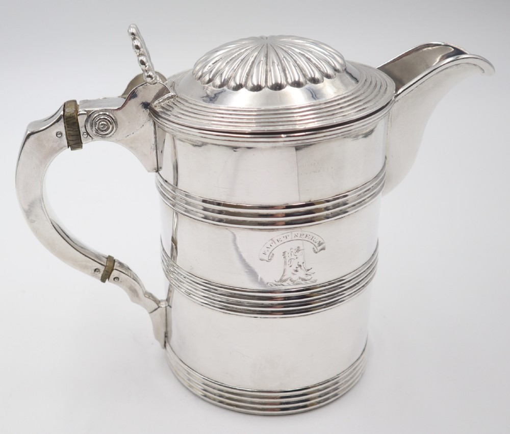An antique silver Old Sheffield plate beer jug featuring reeded horizontal bands, a fluted hinged lid, an engraved heraldic crest, and a curved handle. View IV