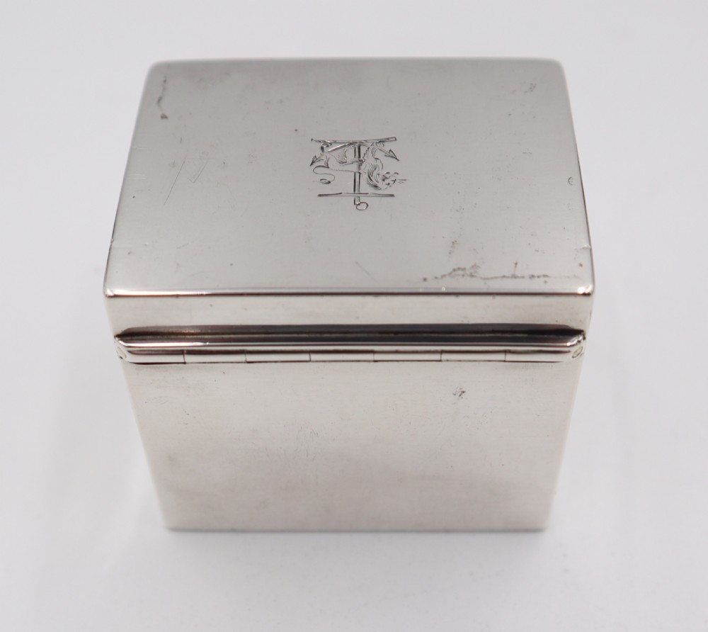 A small rectangular antique sterling silver box with a hinged lid engraved with a heraldic crest. View III