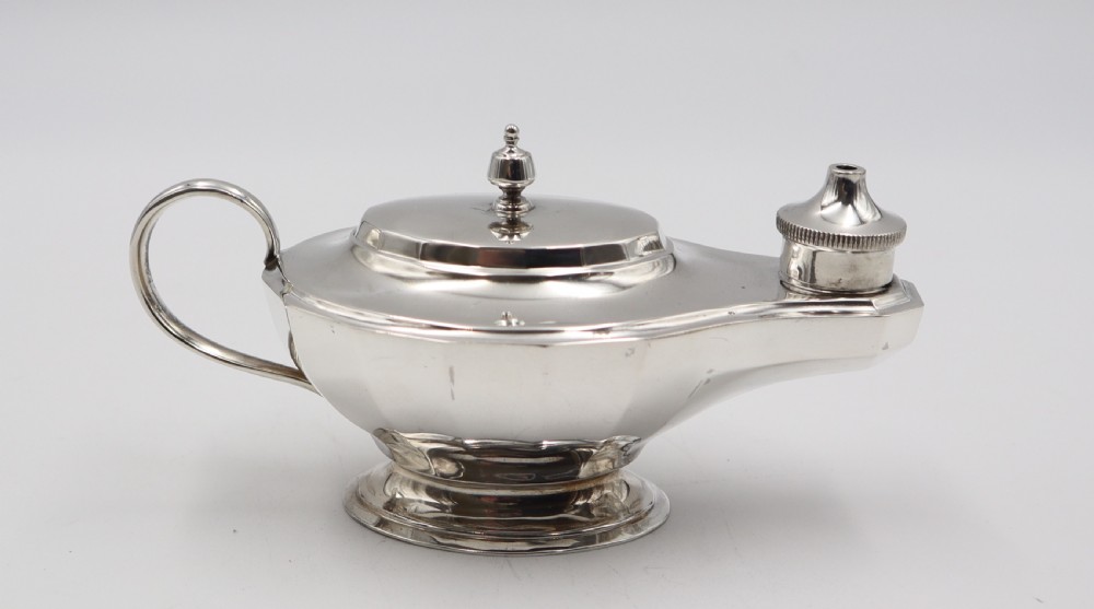 A pair of polished silver table lighters designed in the traditional shape of classical oil lamps with curved loop handles and pedestal bases. View IV