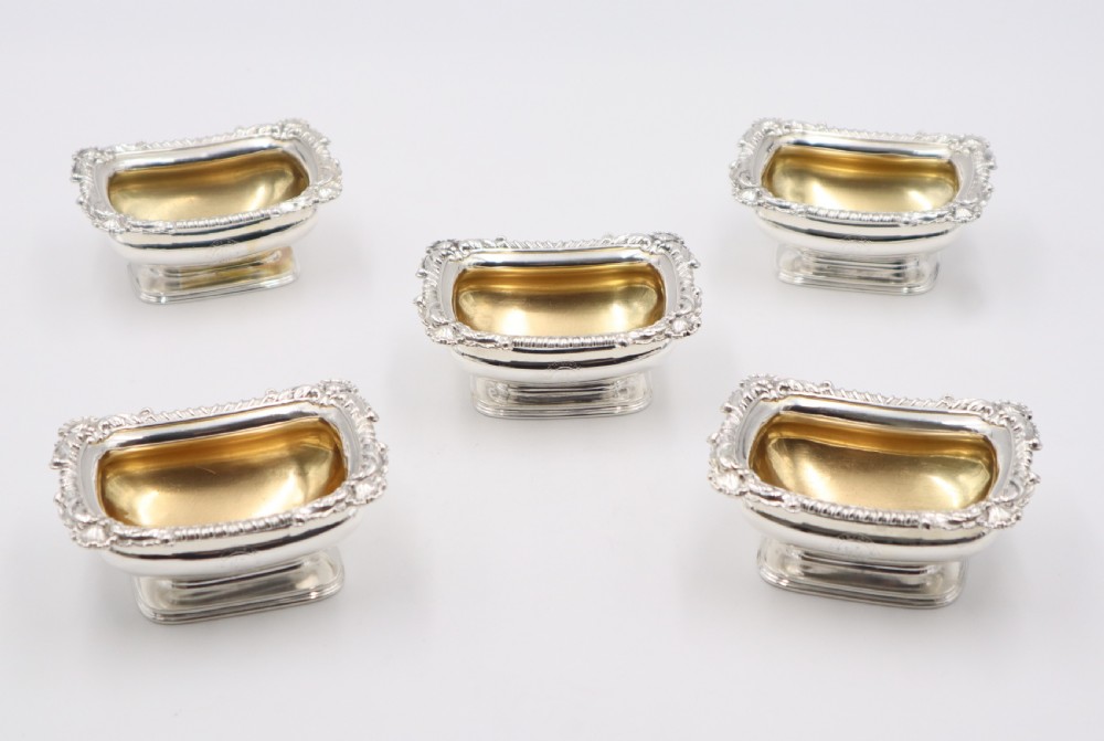 A set of five oblong sterling silver salt cellars featuring gadrooned borders, pedestal bases, and gilded interior bowls. View II