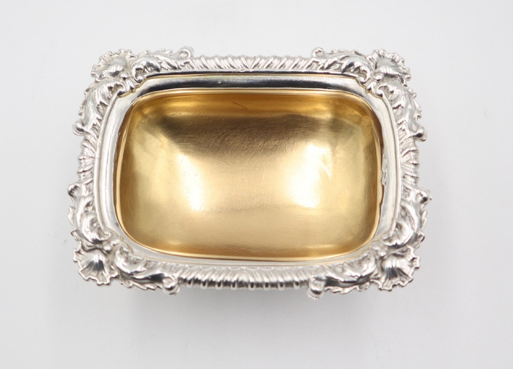 A set of five oblong sterling silver salt cellars featuring gadrooned borders, pedestal bases, and gilded interior bowls. View VI