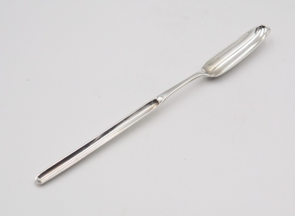 An elongated double-ended sterling silver marrow scoop with a narrow trough at one end and a broader trough at the other.