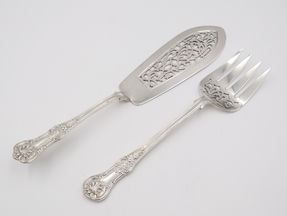 A two-piece set of silver fish servers comprising a pierced blade slice and a matching four-tined fork with decorative scroll handles. View II