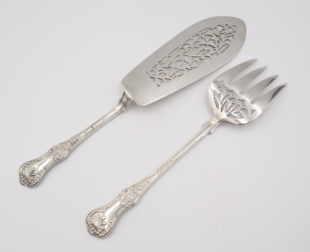 A two-piece set of silver fish servers comprising a pierced blade slice and a matching four-tined fork with decorative scroll handles. View III
