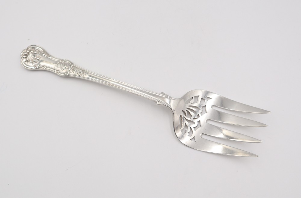 A two-piece set of silver fish servers comprising a pierced blade slice and a matching four-tined fork with decorative scroll handles. View V