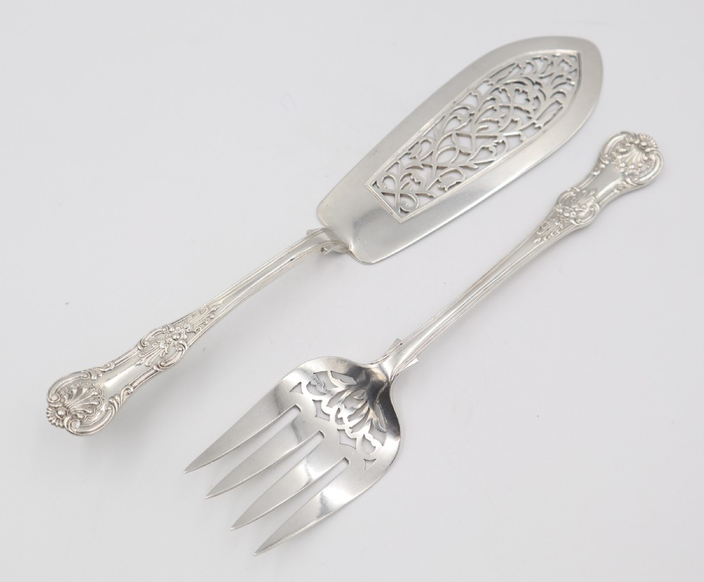 A two-piece set of silver fish servers comprising a pierced blade slice and a matching four-tined fork with decorative scroll handles. View VIII