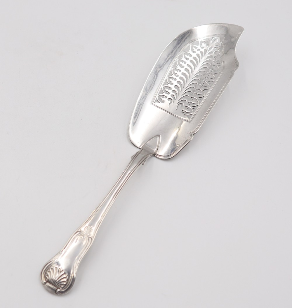An antique sterling silver fish slice featuring a pierced engraved blade and a fiddle and shell pattern handle. View V