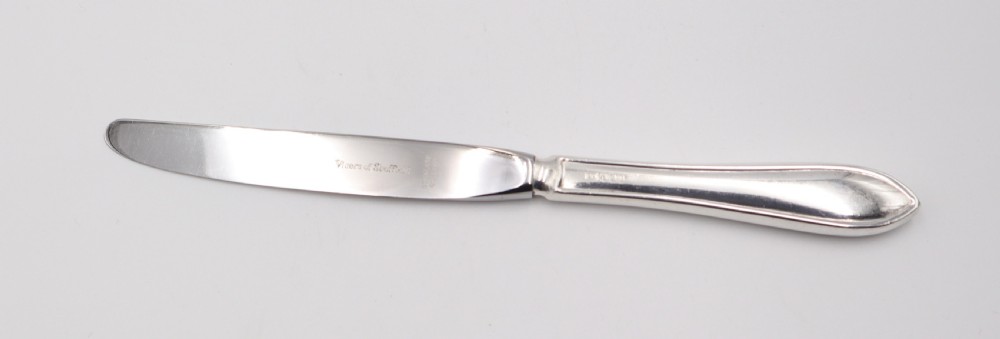 A comprehensive silver cutlery set containing dinner knives, forks, soup spoons, and dessert spoons laid out flat on a light grey background. View VIII
