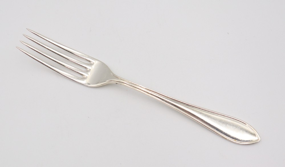 A comprehensive silver cutlery set containing dinner knives, forks, soup spoons, and dessert spoons laid out flat on a light grey background. View IX