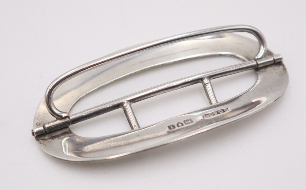 An oval sterling silver buckle featuring a central vertical bar with two pointed prongs. View III