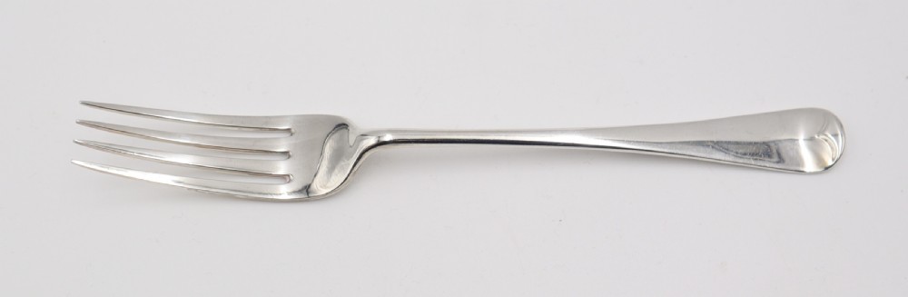 A complete antique silver cutlery set comprising table knives, forks, soup spoons, dessert spoons, and teaspoons arranged neatly on a white background. View V
