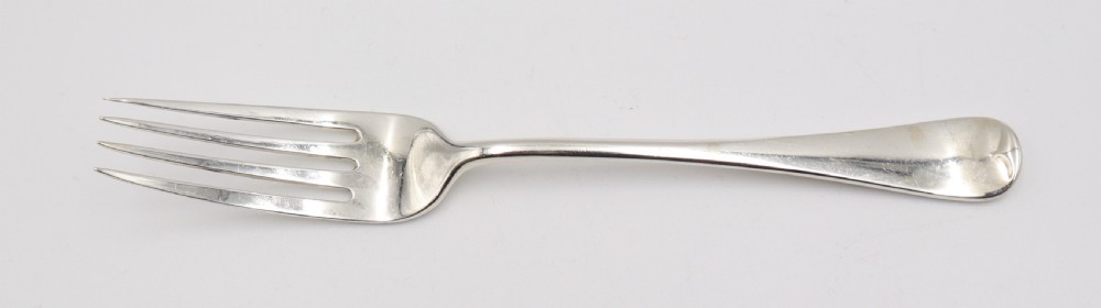 A complete antique silver cutlery set comprising table knives, forks, soup spoons, dessert spoons, and teaspoons arranged neatly on a white background. View VII