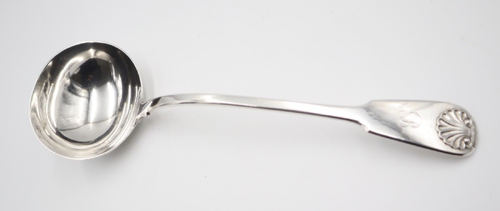 An antique silver soup ladle featuring a deep circular bowl, a slender arched stem, and a shell detail on the handle terminal. View III