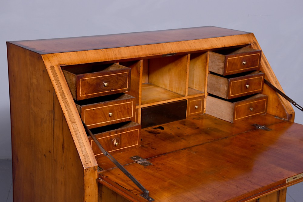 A 19th-century blonde walnut slant-front bureau featuring rosewood inlay, a central star motif on the lid, and three long drawers with decorative metal handles. View III
