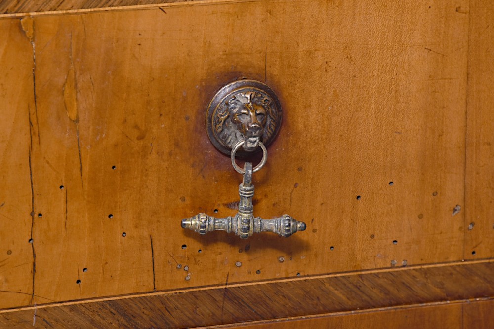 A 19th-century blonde walnut slant-front bureau featuring rosewood inlay, a central star motif on the lid, and three long drawers with decorative metal handles. View X