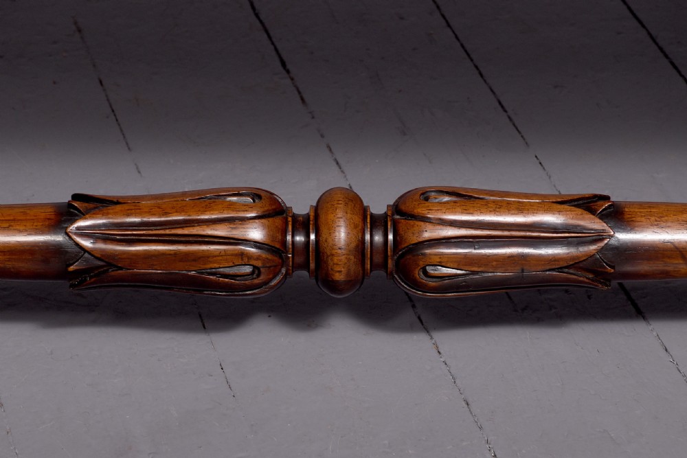 A William IV rosewood library table featuring a rectangular top, two frieze drawers, carved scroll brackets, end pedestal supports, and a turned central stretcher. View II