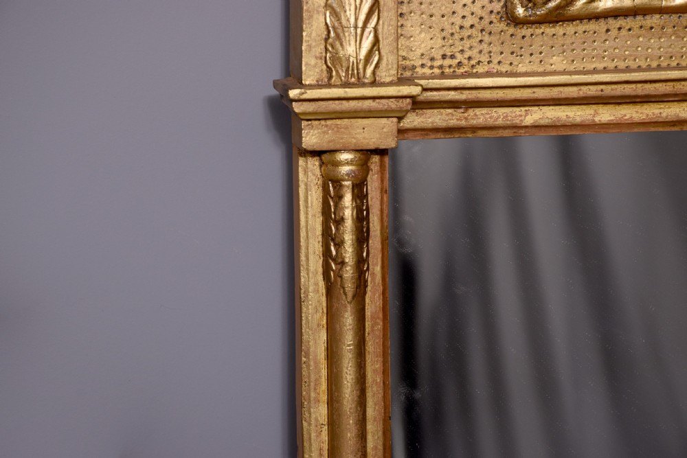 A Regency gilded wood pier mirror featuring a ball-decorated cornice, a classical figure relief frieze, and reeded side columns framing rectangular glass. View III
