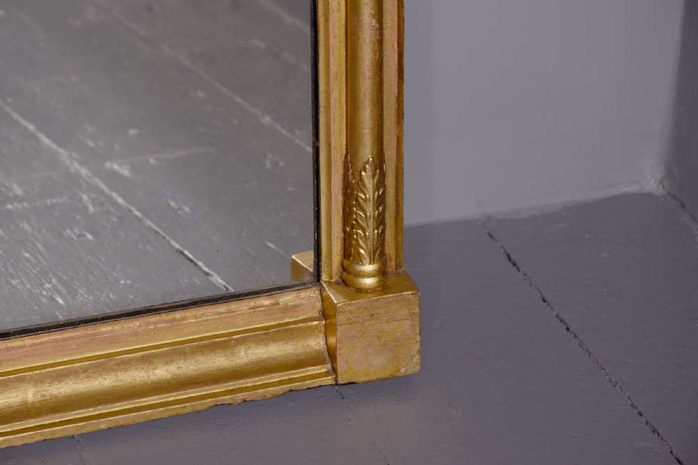 A Regency gilded wood pier mirror featuring a ball-decorated cornice, a classical figure relief frieze, and reeded side columns framing rectangular glass. View V