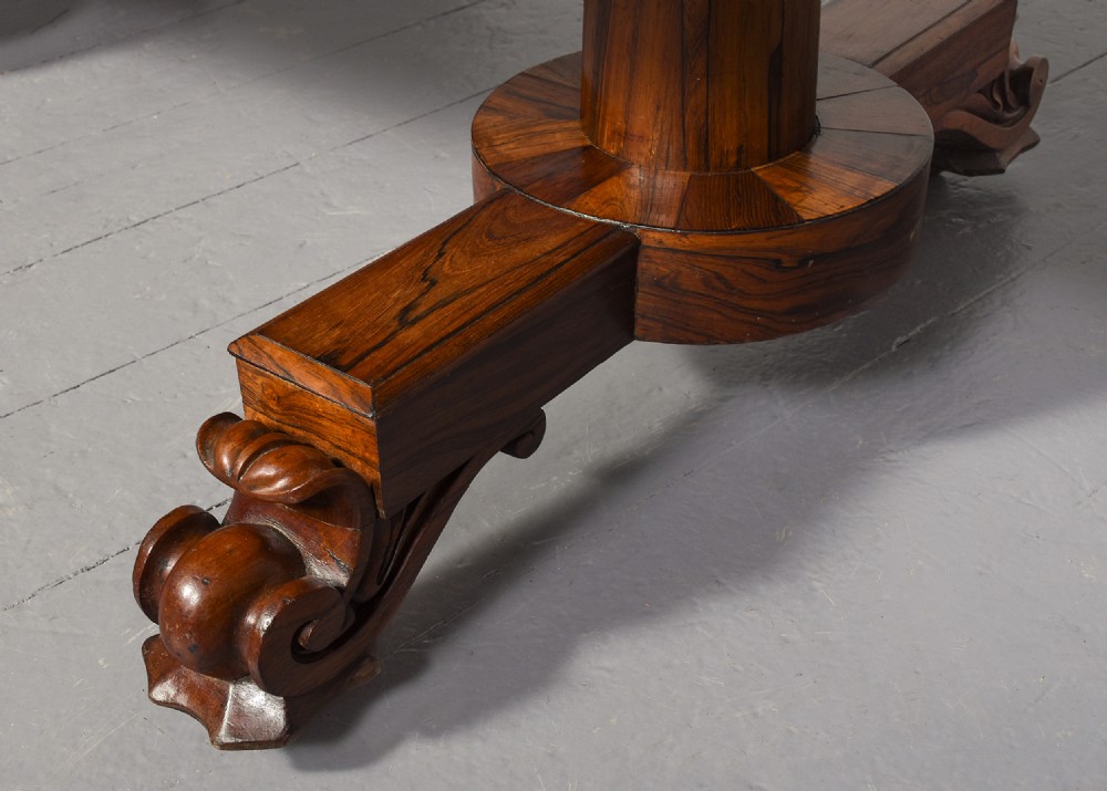 A low rectangular rosewood coffee table featuring twin turned pedestal supports, carved scroll feet, and brass castors. View III