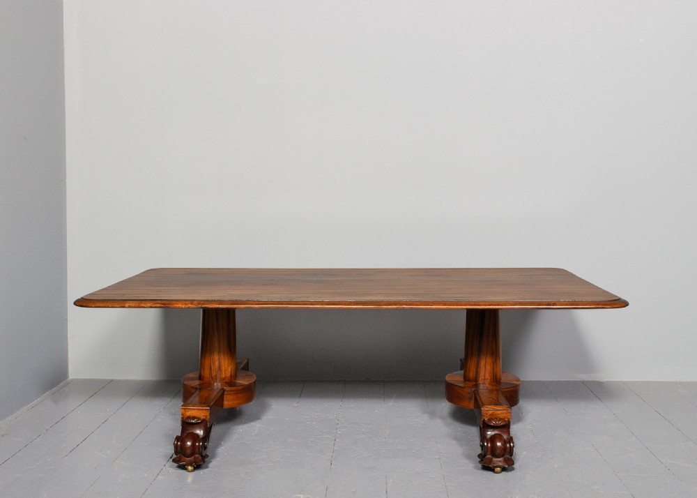 A low rectangular rosewood coffee table featuring twin turned pedestal supports, carved scroll feet, and brass castors. View IV