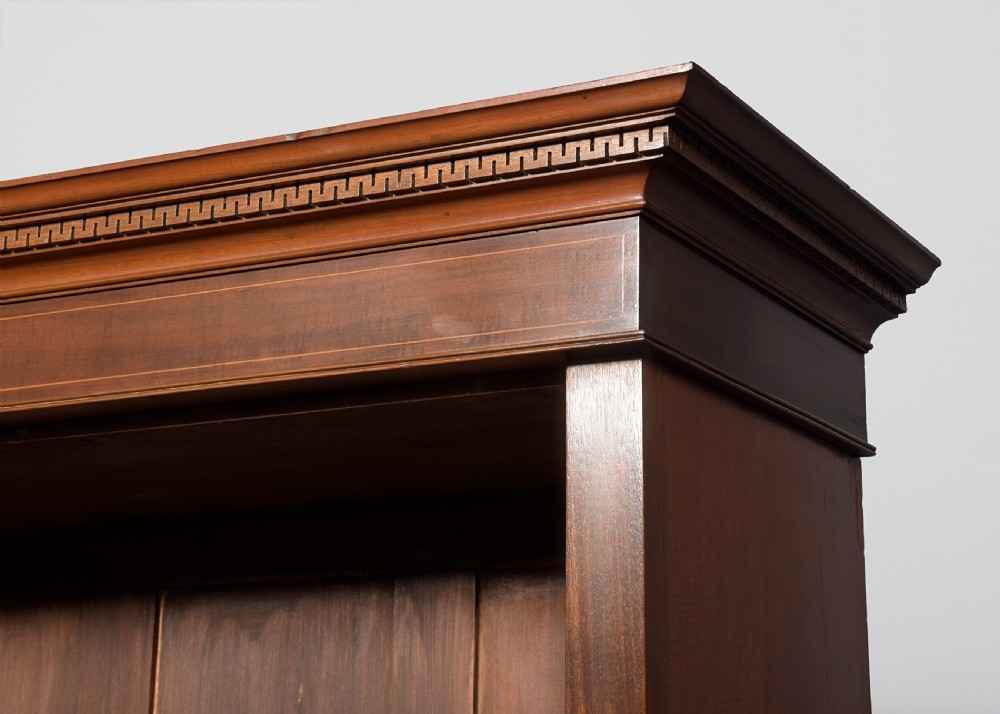A wide dark mahogany open bookcase featuring twin double bays with multiple shelves, decorative inlay on the frieze, carved shell motifs on the lower apron, and cabriole legs ending in ball and claw feet. View IV