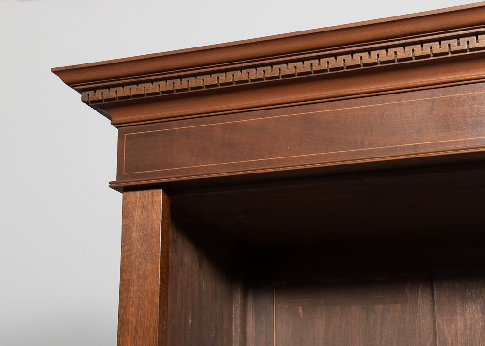 A wide dark mahogany open bookcase featuring twin double bays with multiple shelves, decorative inlay on the frieze, carved shell motifs on the lower apron, and cabriole legs ending in ball and claw feet. View VIII