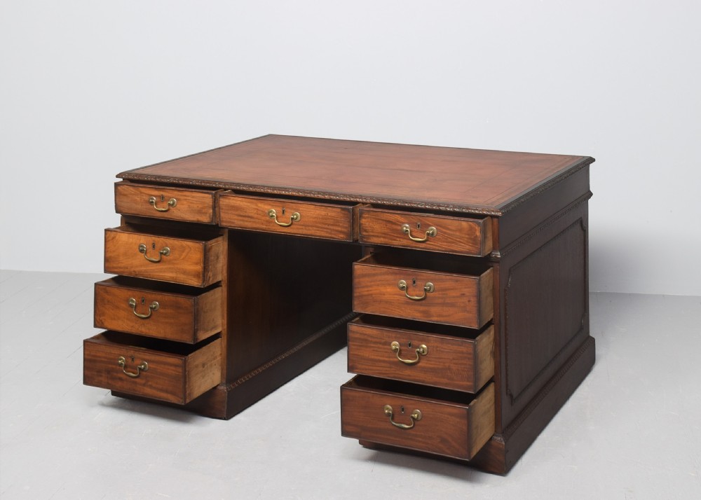 A George III mahogany partners desk featuring dual pedestals with drawers, brass handles, and a leather inset writing surface. View III