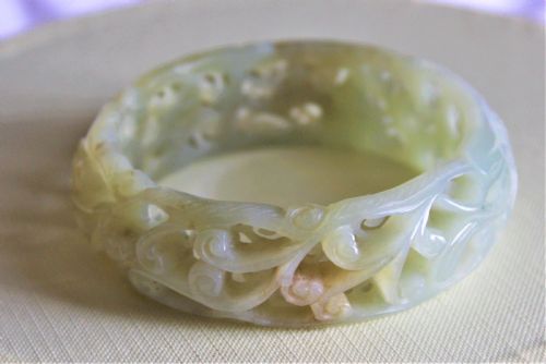 A Very Fine and Deeply Carved Chinese Celadon Jade Bangle