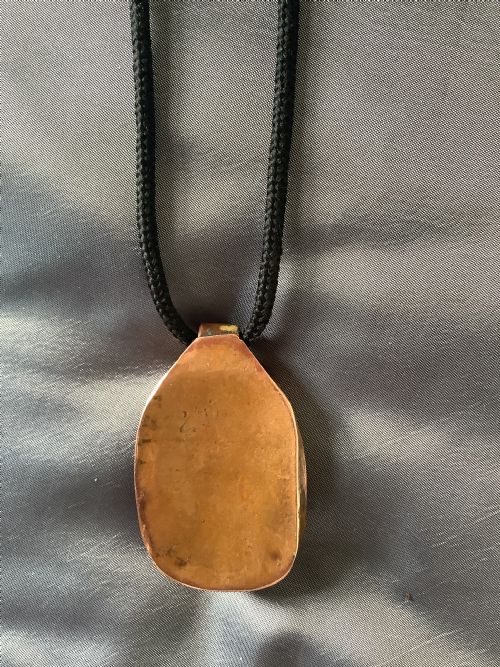 A VERY FINELY CARVED BONE INDIAN PENDANT ENCASED IN A METAL FRAME - ADDITIONAL PHOTO 4