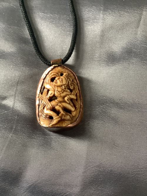 A VERY FINELY CARVED BONE INDIAN PENDANT ENCASED IN A METAL FRAME - ADDITIONAL PHOTO 5