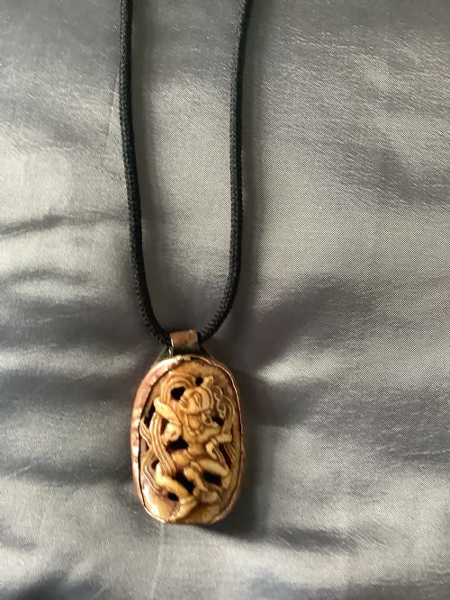 A VERY FINELY CARVED BONE INDIAN PENDANT ENCASED IN A METAL FRAME - ADDITIONAL PHOTO 6