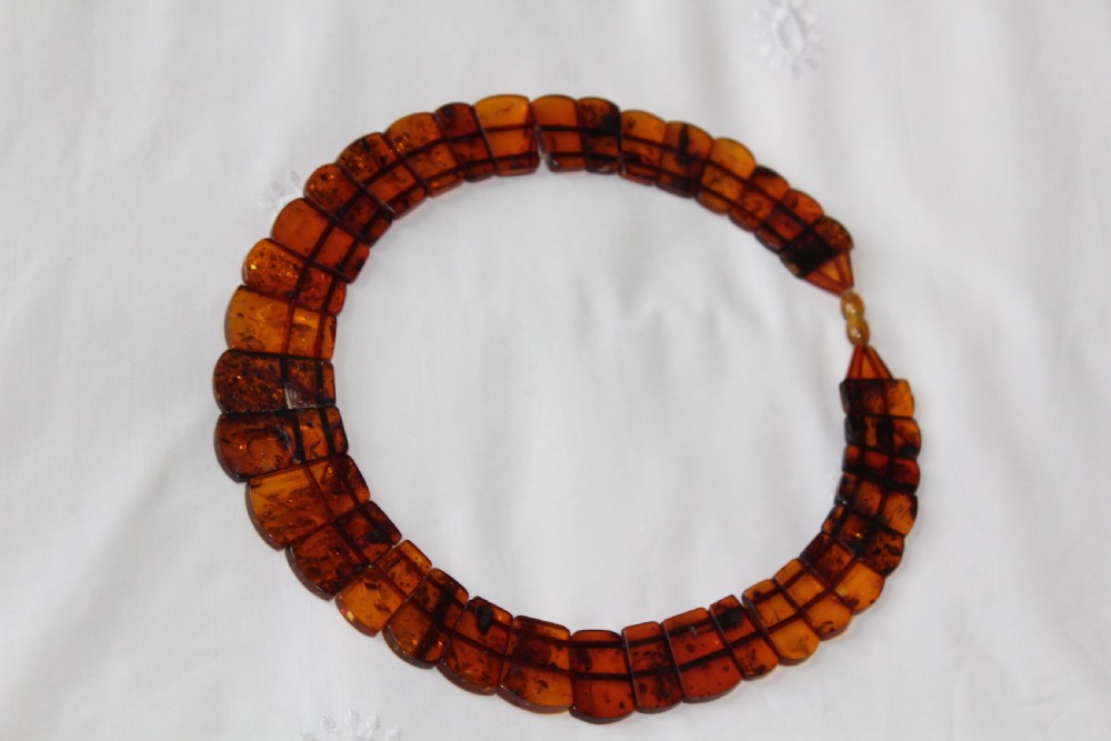 An Art Deco Baltic amber necklace featuring graduated rectangular polished cognac amber beads strung in a curved collar layout. View II