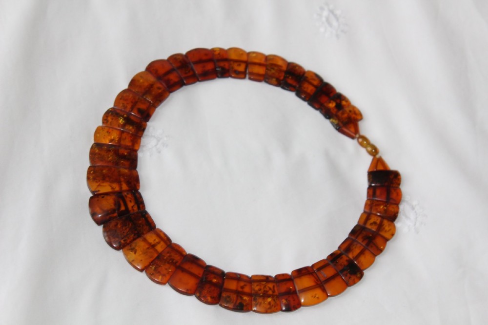 An Art Deco Baltic amber necklace featuring graduated rectangular polished cognac amber beads strung in a curved collar layout. View III