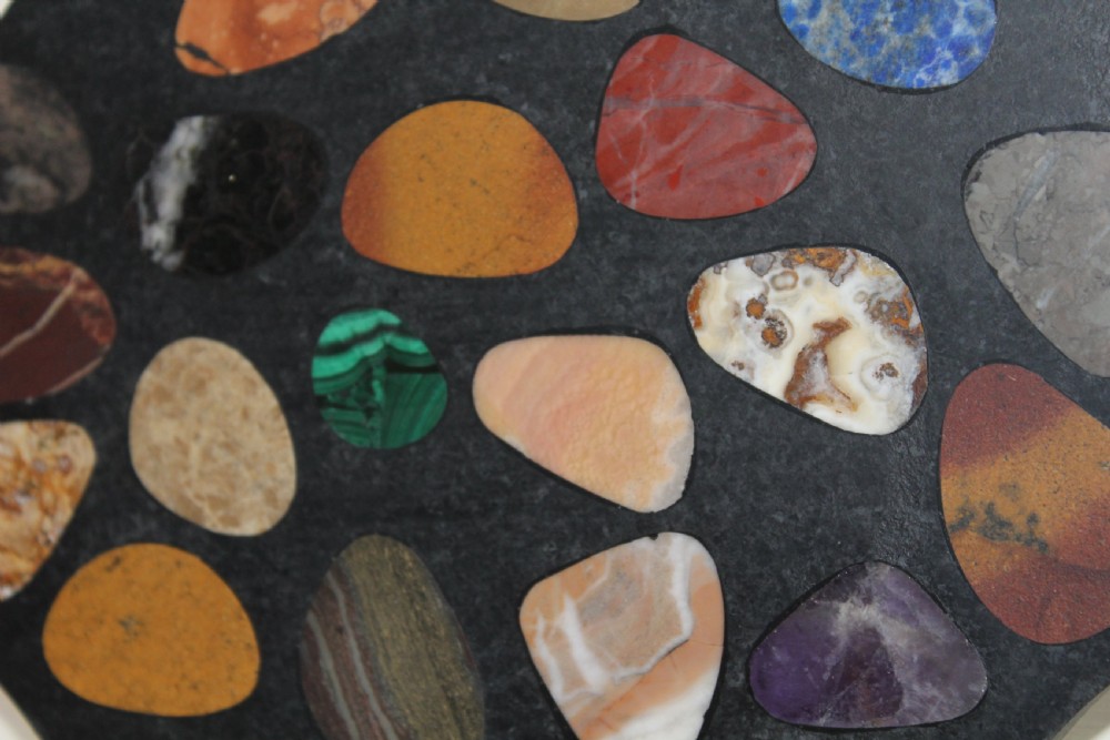 A shaped dark slate plaque inlaid with various polished colorful specimen stones including malachite and agates. View IV
